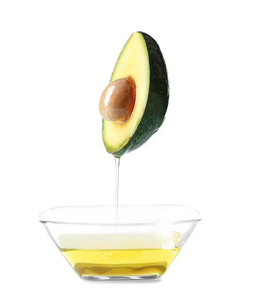 Avocado and bowl with avocado oil on white background. — Stock Photo, Image