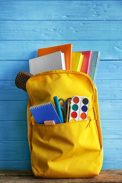 Mochila escolar con accesorios sobre fondo de madera —  Fotos de Stock