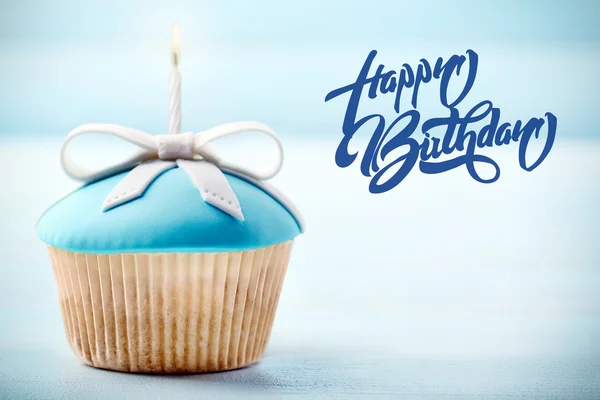 Delicioso cupcake sobre fondo azul. Concepto de feliz cumpleaños . — Foto de Stock