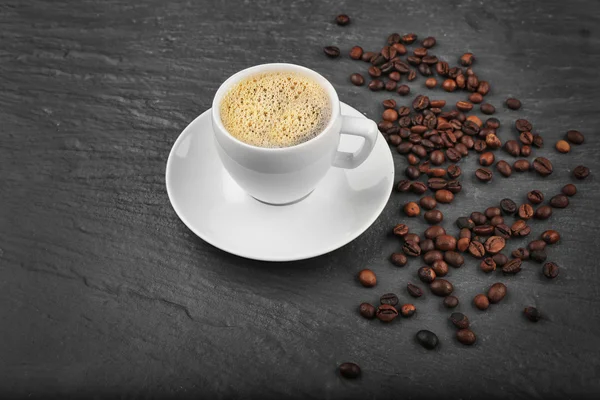 Secangkir kopi dengan kacang di latar belakang bertekstur abu-abu — Stok Foto