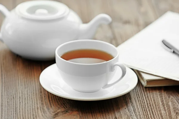 Tasse de thé avec journal sur la table — Photo