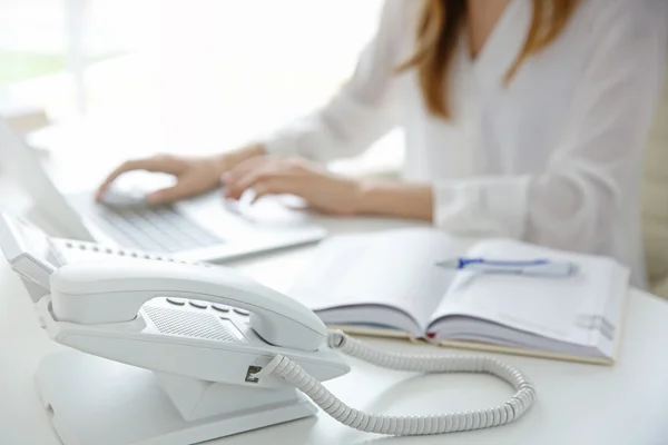 Geschäftsfrau mit Büro-IP-Telefon — Stockfoto