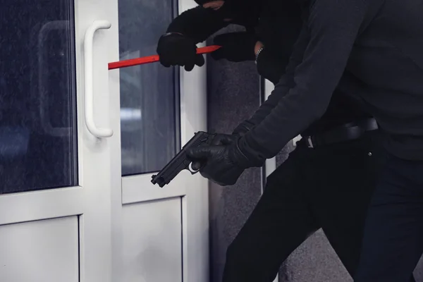 Armed thieves breaking a door