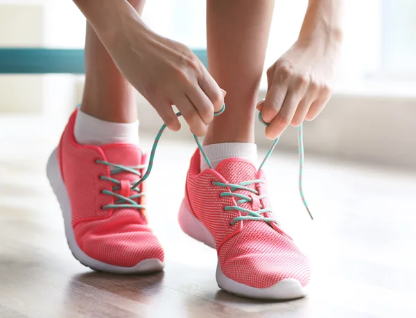 Vrouw koppelverkoop haar roze sneakers — Stockfoto