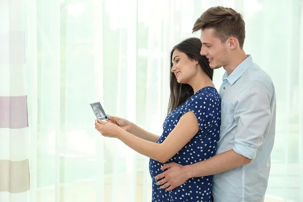 Беременная пара смотрит на ультразвуковое изображение — стоковое фото