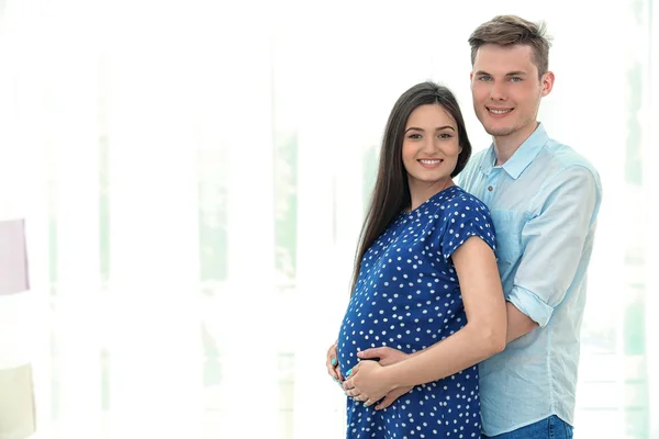 Jovem casal grávida no fundo claro — Fotografia de Stock