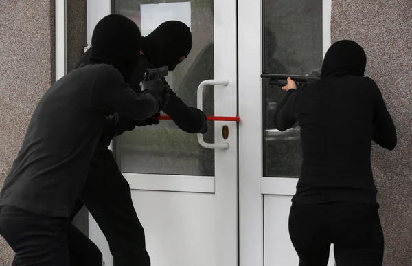 一群武装的盗贼打破一扇门 — 图库照片