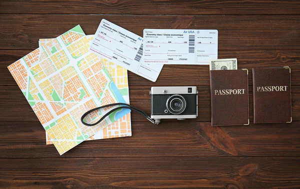 Cámara vintage con mapa, pasaportes y dinero en efectivo sobre fondo de madera —  Fotos de Stock