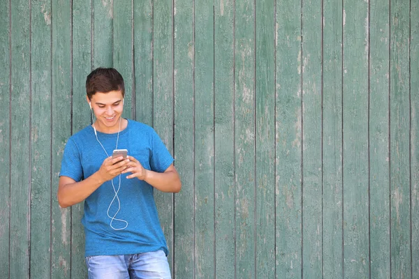 Schöner Kerl Der Musik Auf Hölzernem Hintergrund Hört — Stockfoto