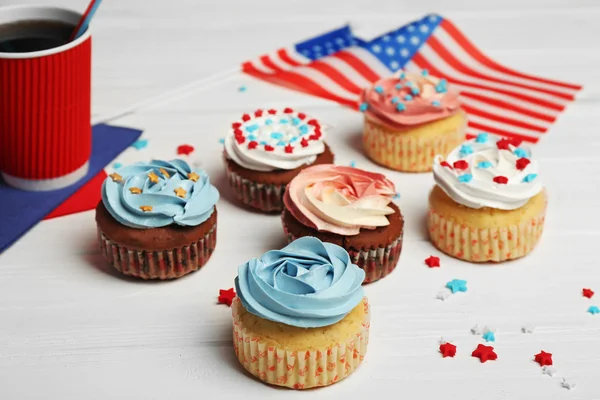 Délicieux cupcakes et boisson sur fond de bois blanc — Photo