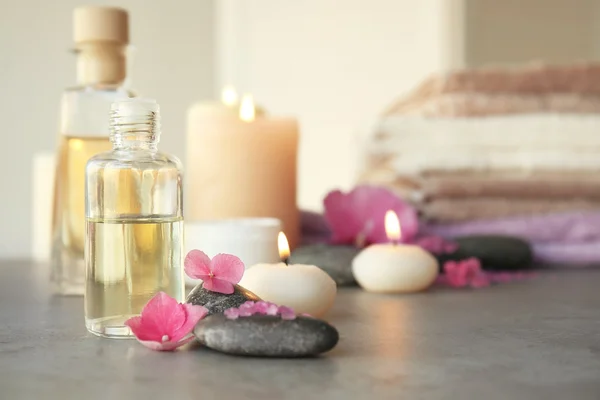 Composición del spa con aceite y flores en la mesa, primer plano — Foto de Stock