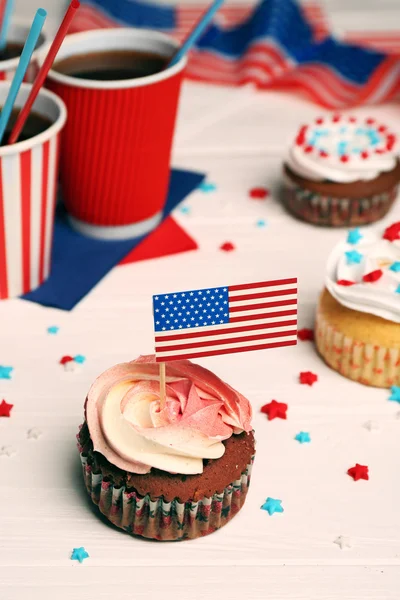 Delicioso cupcake com decoração de bandeira e bebida em fundo de madeira branca Fotografias De Stock Royalty-Free