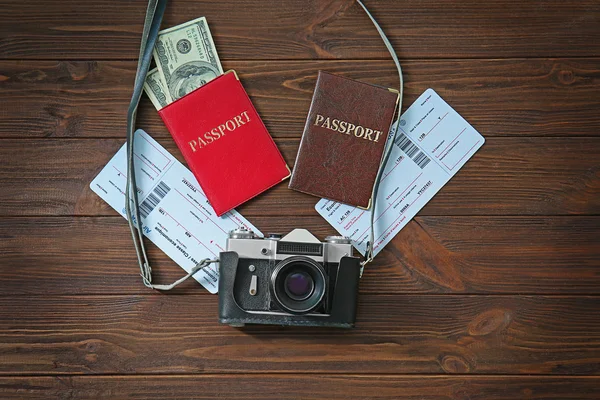 Câmera vintage com passaportes e dinheiro em fundo de madeira — Fotografia de Stock