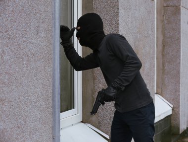 Silahlı hırsız pencereden bakıyor