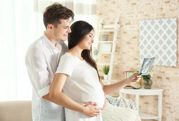 怀孕的夫妇看超声图像 — 图库照片