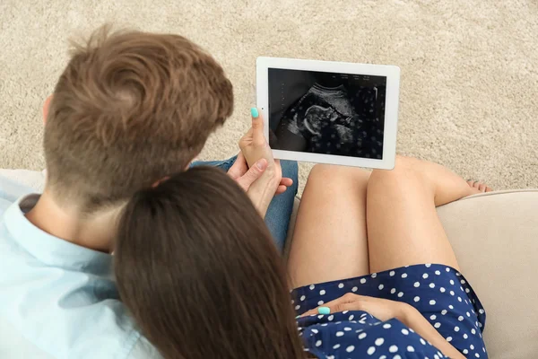 Zwangere paar kijkend echografie afbeelding — Stockfoto