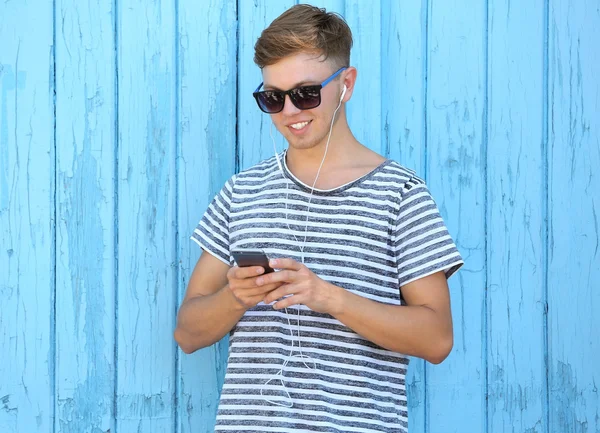 Schöner Kerl Der Musik Auf Hölzernem Hintergrund Hört — Stockfoto