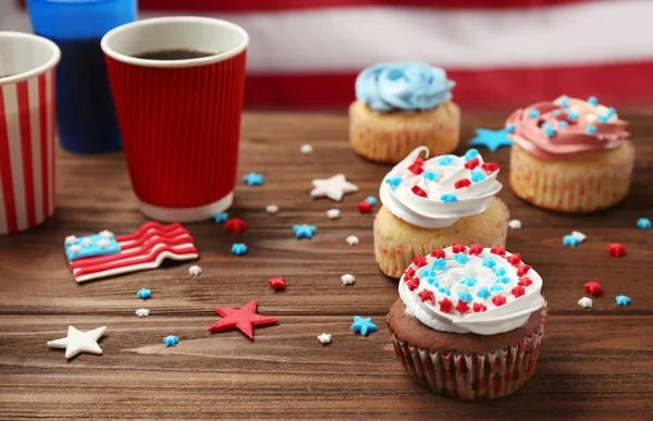 Deliciosos cupcakes e bebidas em mesa de madeira — Fotografia de Stock