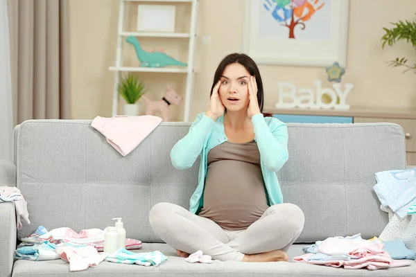Mujer embarazada con ropa de bebé —  Fotos de Stock