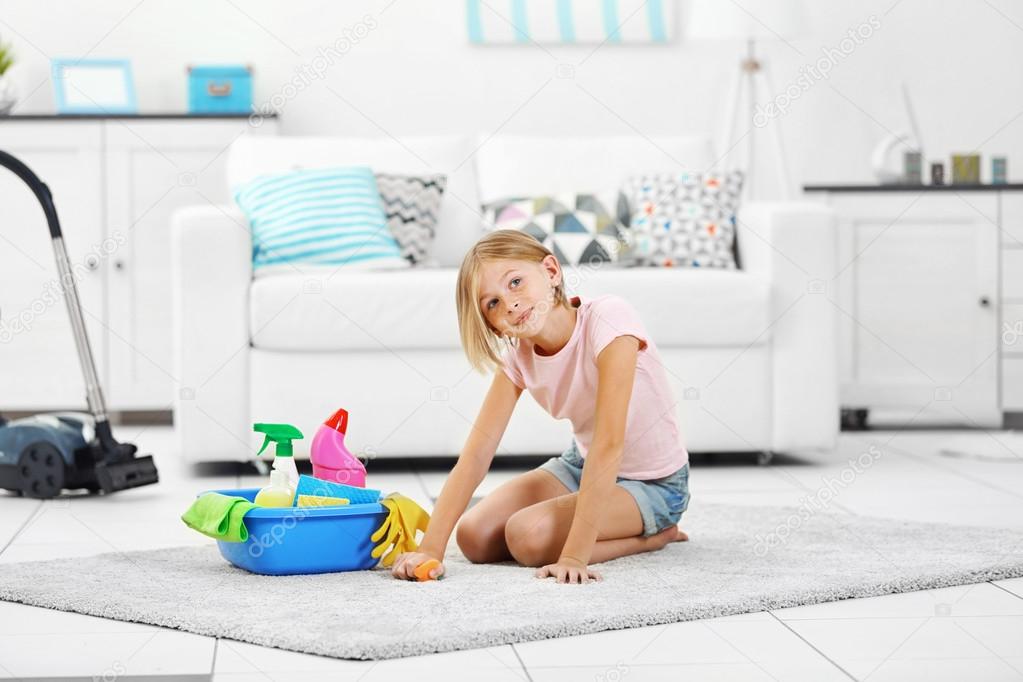 Little girl cleaning floor carpet