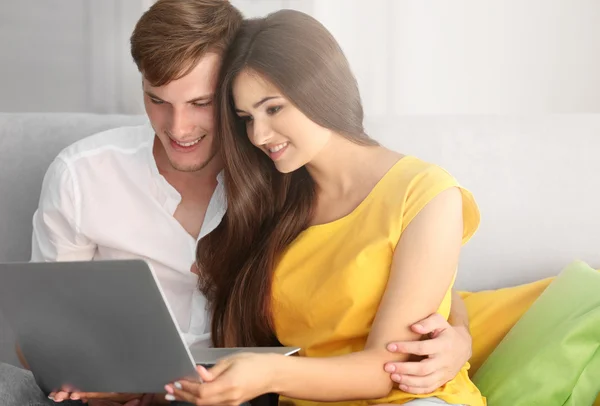 美丽的夫妇在家的笔记本电脑上冲浪互联网 — 图库照片