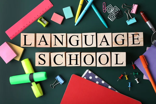 Colourful stationery and words LANGUAGE SCHOOL on chalkboard — Stock Photo, Image