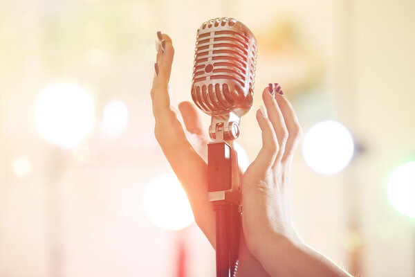 Female hand with vintage microphone  