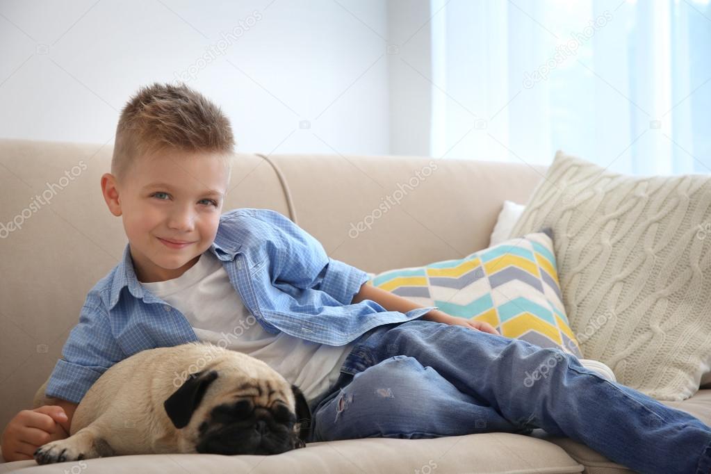 boy with pug dog on couch