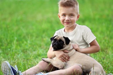 çocuk ile pug köpek yeşil çimenlerin üzerinde