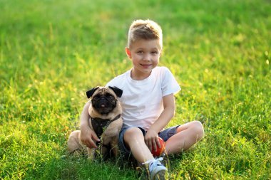 çocuk ile pug köpek yeşil çimenlerin üzerinde