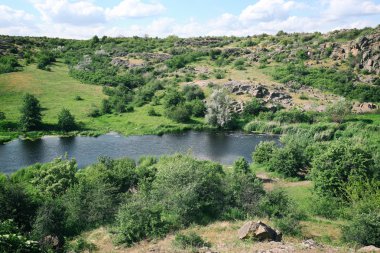 mavi gökyüzünün altında yeşil tepeler
