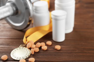 Sporda doping. Halter, madalya ve uyuşturucu ahşap arka plan