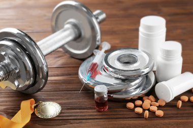 Sporda doping. Halter, madalya ve uyuşturucu ahşap arka plan