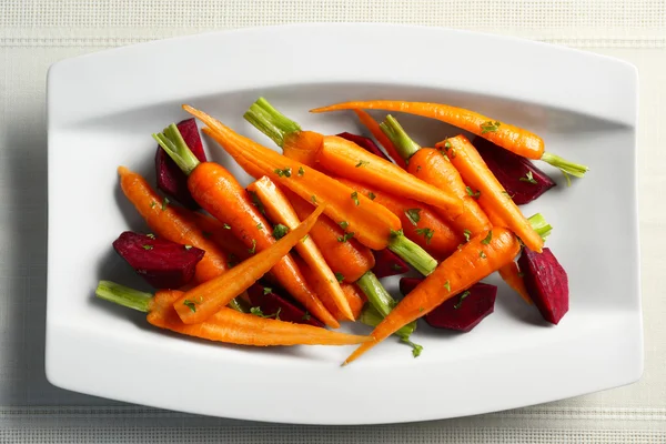 Delicious snack with baby carrots on white plate, top view — Stock fotografie