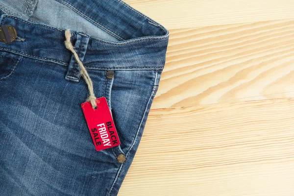 Försäljning koncept. Kvinnliga jeans på träbord, platt låg — Stockfoto