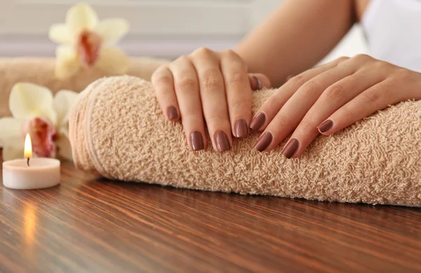 Vrouwelijke bruin manicure op handdoek, close-up — Stockfoto