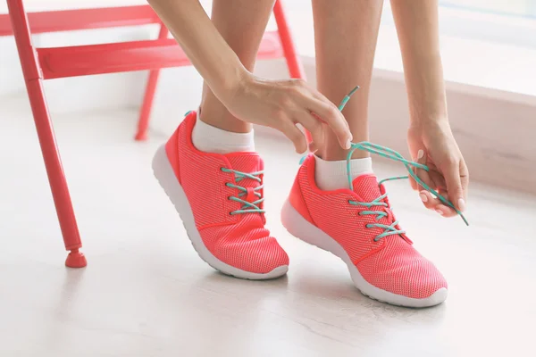 Mujer atando sus zapatillas rosadas — Foto de Stock