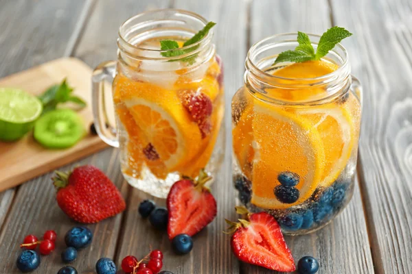 Uppfriskande vatten med frukter på bord — Stockfoto