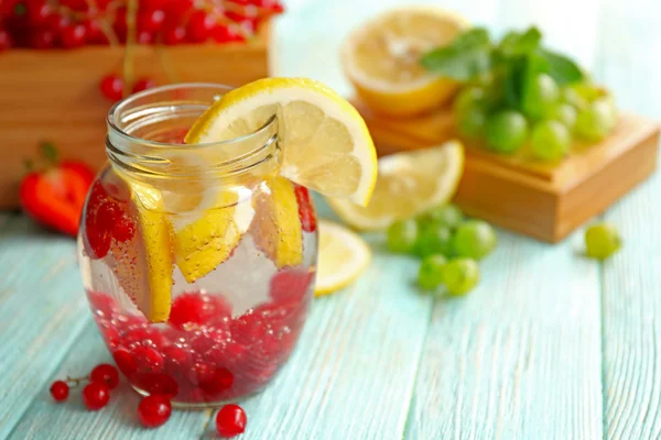 Agua refrescante con frutas en la mesa — Foto de Stock