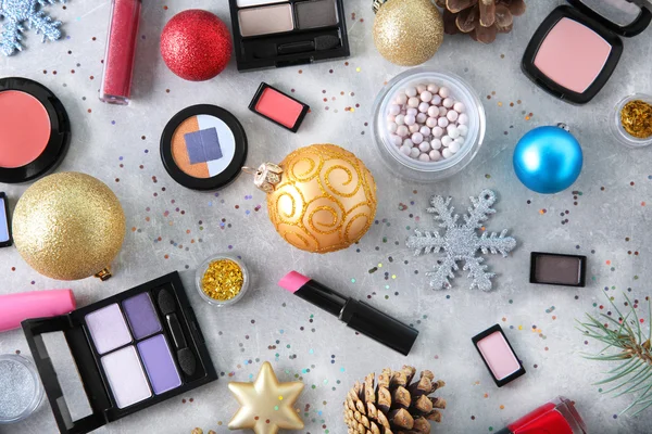 Makeup products and Christmas decorations on color background — Stock Photo, Image