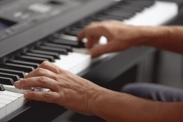 hands playing on synthesizer