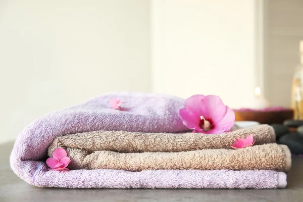 Wellnesskomposition mit Handtüchern und Blumen auf dem Tisch — Stockfoto