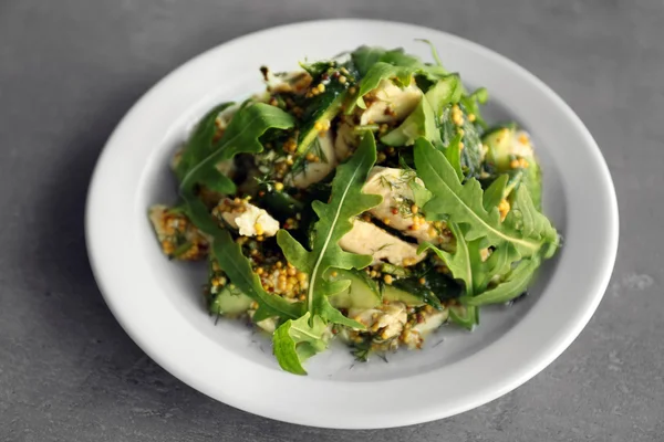 Ensalada sabrosa con pollo, pepinos y rúcula en plato — Foto de Stock