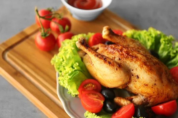 Placa con pollo asado, aceitunas y tomates sobre tabla de cortar de madera —  Fotos de Stock