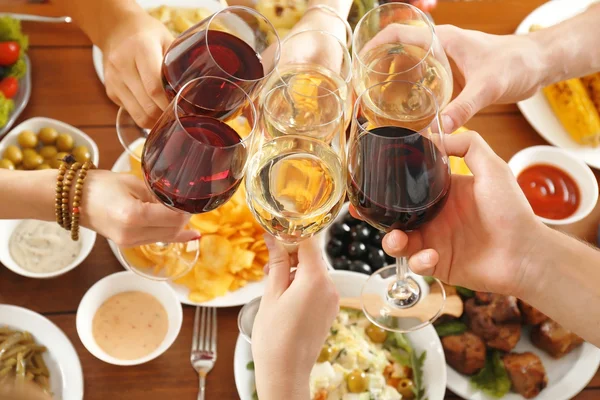 Amigos aplaudindo com copos de vinho no restaurante — Fotografia de Stock