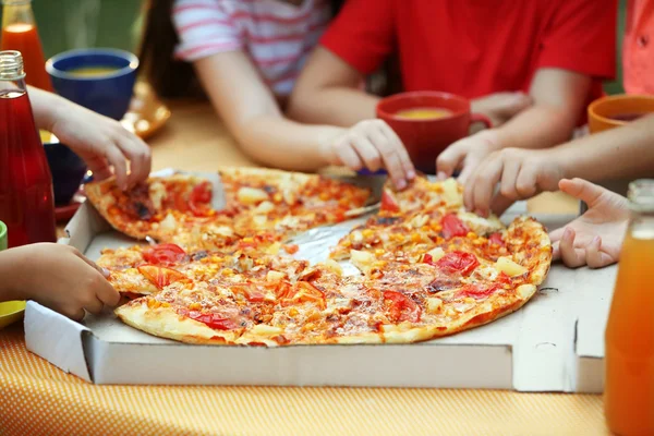 Děti jíst pizzu v parku — Stock fotografie