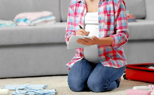 Pregnant woman making packing — Stock Photo, Image