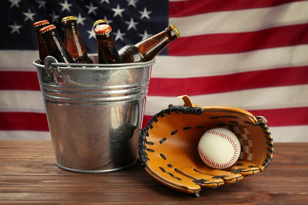 Luva de beisebol com bola e cerveja na mesa de madeira — Fotografia de Stock