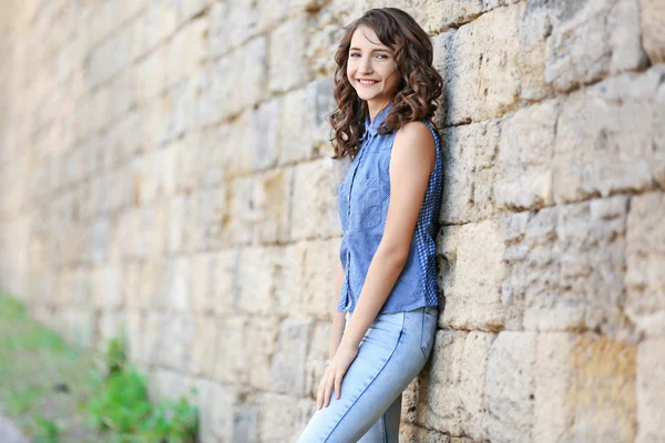 Mooi meisje die zich voordeed op bakstenen muur achtergrond — Stockfoto