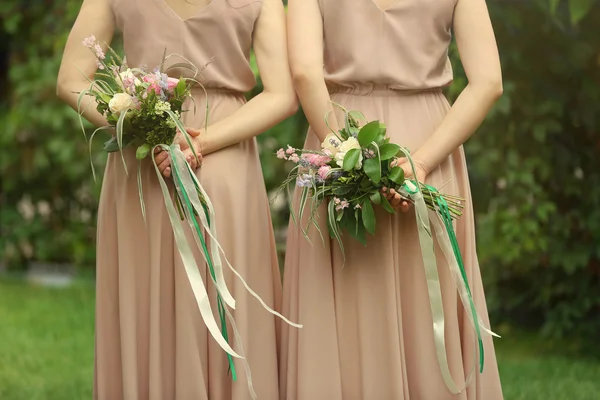 Hermosas damas de honor sosteniendo ramos —  Fotos de Stock